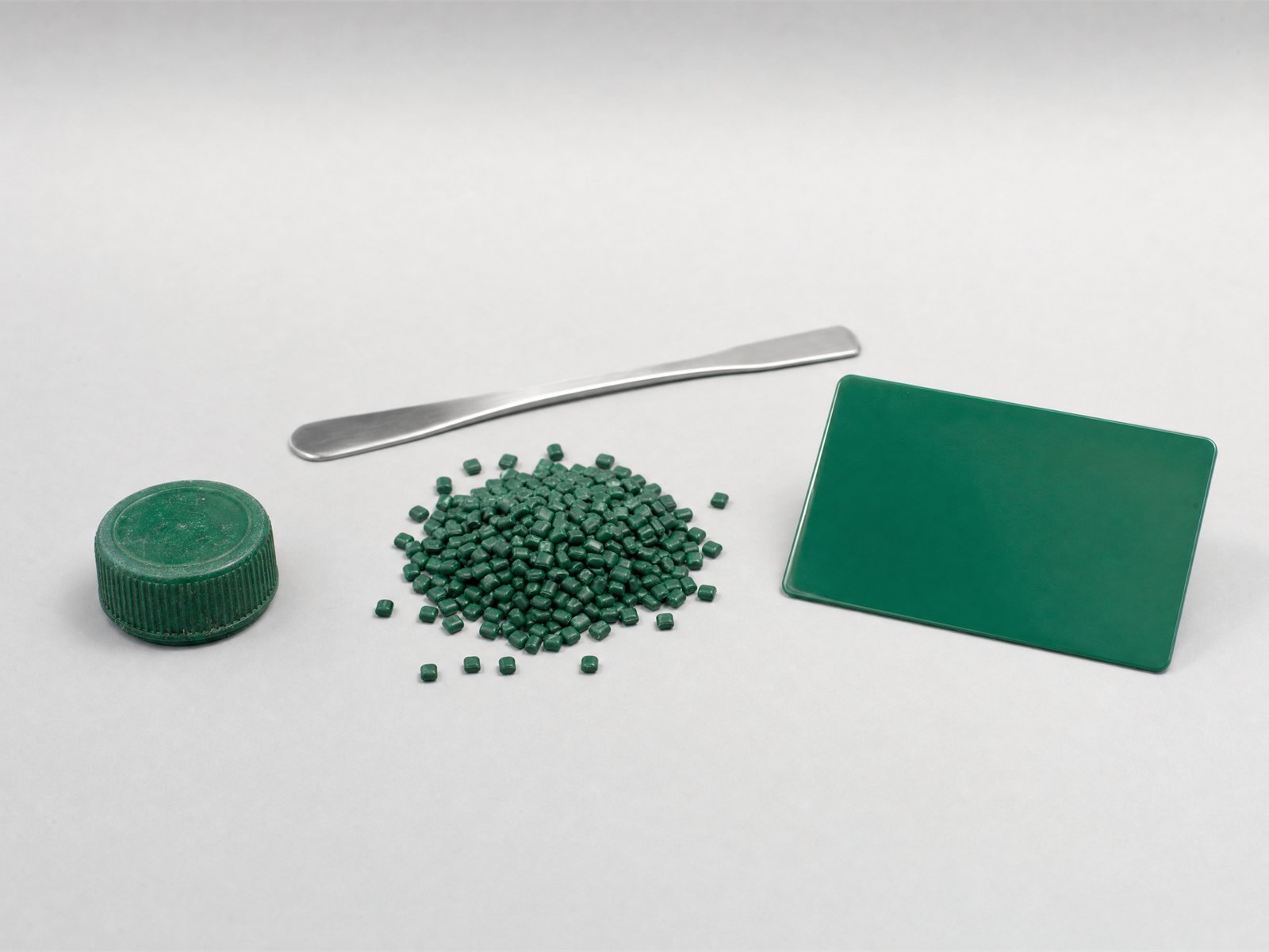 Tapa de plástico verde del cliente, pellets de masterbatch del mismo tono y la placa moldeada resultante