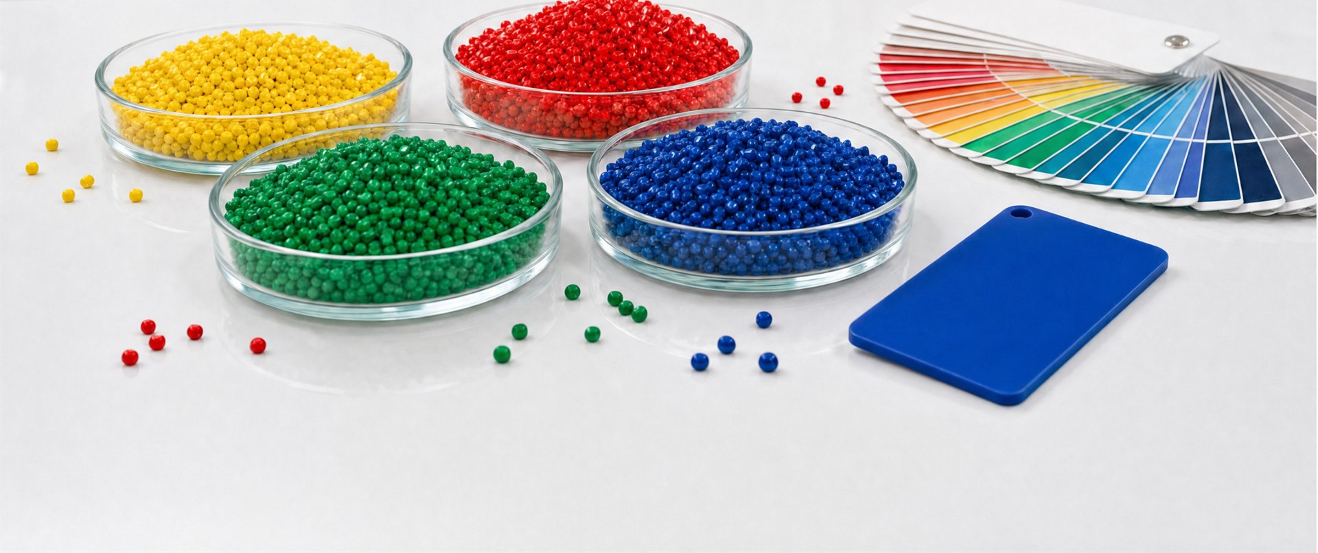 Cuatro cajas Petri con pellets amarillos, rojos, verdes y azules, abanico de referencia de color y una placa azul